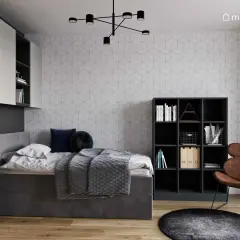 Nowoczesny pokoj nastolatka z szarą pościelą, regałami i wygodnym fotelem.