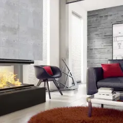 Nowoczesny salon z betonową ścianą i kominkiem. Zastanawiasz się, czym obłożyć kominek w salonie? Tutaj betonowa obudowa idealnie komponuje się z wnętrzem.