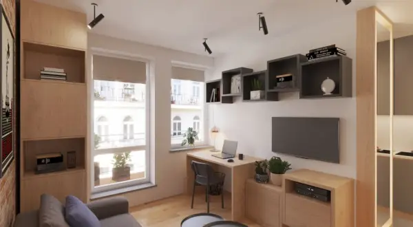 Przytulny salon w bloku z kącikiem do pracy przy oknie, wygodną kanapą i półkami na książki.