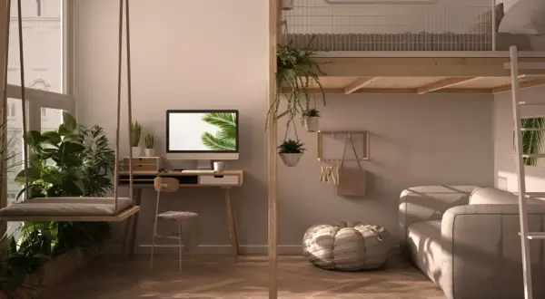 Przytulna **antresola w domu** z huśtawką, biurkiem i sofą. Wnętrze pełne zieleni i naturalnego światła.