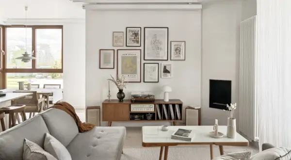 Salon w stylu retro inspiracje: szara kanapa, drewniana komoda z gramofonem i płytami, galeria ścienna z grafikami, stolik kawowy.