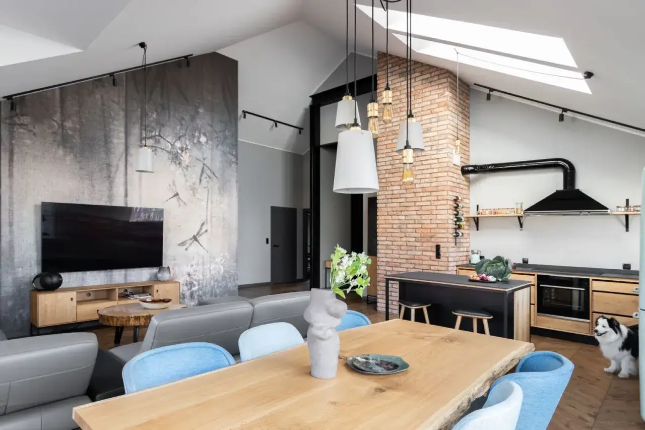 Nowoczesna aranżacja salonu w stylu loft z tapetą w ważki, ceglaną ścianą i drewnianym stołem.