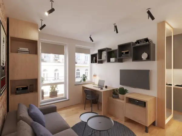Przytulny salon w bloku z kącikiem do pracy przy oknie, wygodną kanapą i półkami na książki.